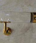 Built Tough And Smooth As Glass, Clear Acrylic Stair Handrail With Gold Brackets, close-up view highlighting gold bracket.
