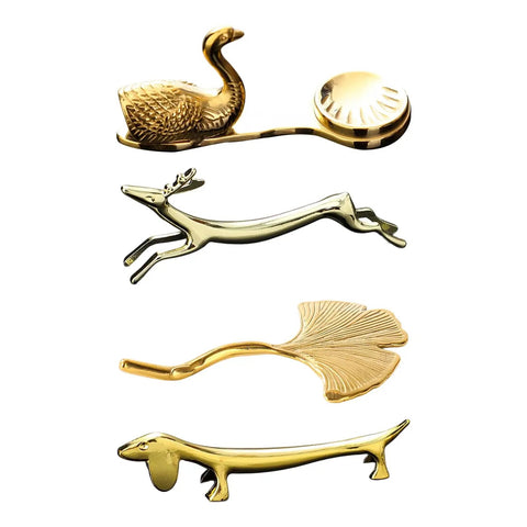 Gold-tone animal and leaf-shaped cutlery rests arranged vertically.