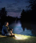 Man fishing by a lake at night illuminated by Beast Mode Bright Rechargeable Portable LED Work Light With Stand 8000 Lumen Output