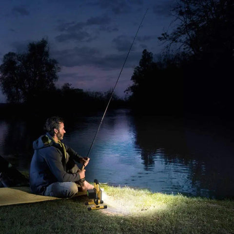 Man fishing by a lake at night illuminated by Beast Mode Bright Rechargeable Portable LED Work Light With Stand 8000 Lumen Output