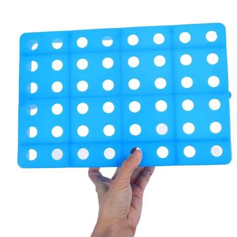Person holding a blue Ventilated Plastic Floor Riser Pallet with raised design and forklift friendly structure, perforated surface.