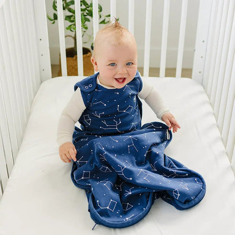 Baby in crib wearing Ultimate Baby Sleep Sack For 4 Season Merino Wool Sleeping Bag With Organic Cotton Outer Night Sky design