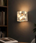 4.7" Mid Century Modern Wall Sconce, Minimalist Terrazzo Wall Light Fixture illuminating a dark wall with dappled shadows.