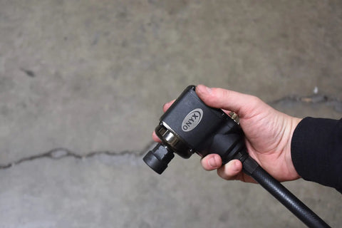 Onyx Three Eighths Inch Palm Impact Wrench Delivers 445 Foot Pounds Of Torque With Remote Throttle And 25 Inch Swivel Hose in hand