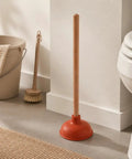 Six Inch Red Rubber Plunger With Sturdy Wood Handle Built For Light Duty Bathroom Drain And Toilet Jobs That Knock Out Stubborn Clogs Without Any Drama in bathroom setting.