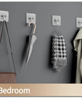 Heavy Duty Self Adhesive Hooks 27 Pack Up To 25 Lb Capacity Stainless Steel Sticky Hangers holding purse, umbrella, scarf in bedroom.