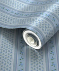 Blue Floral Stripe Wallpaper Featuring Silver Metallic Accents And Textured Fibrous Weave rolled up, showing floral design and colors.
