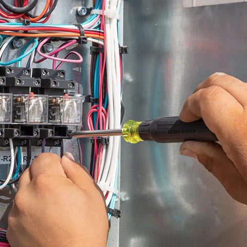 27 In 1 Precision Screwdriver Set With Onboard Storage And Rare Earth Magnet, 26 Precision Bits Plus A 3.5 Mm Nut Driver in use on terminal block