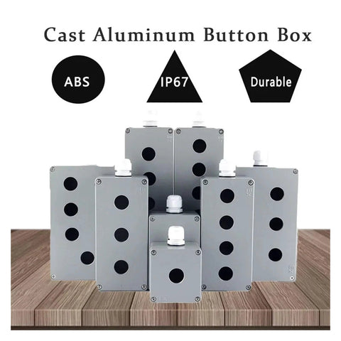 Front view of multiple cast aluminum push-button switch boxes with 22 mm knockouts, IP67 rating on gray enclosures.