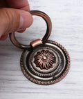 Close-up of a vintage metal cabinet knob with a floral design, part of a 5-piece round vintage single-hole drawer pulls set.