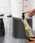 Five Gallon Round White Cold Brew Bucket System For Commercial Use With Drip Free Spigot And Recipe Guide being used to fill carafe
