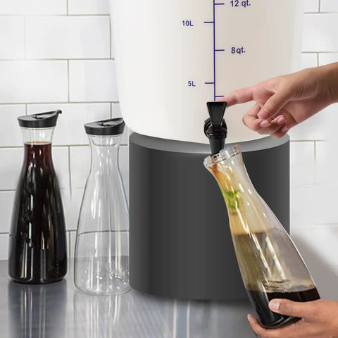 Five Gallon Round White Cold Brew Bucket System For Commercial Use With Drip Free Spigot And Recipe Guide being used to fill carafe