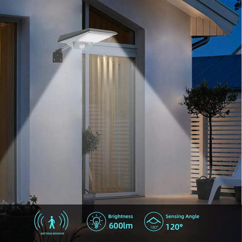 Outdoor solar motion sensor wall light illuminating house facade at night with 600lm brightness and 120° sensing angle.