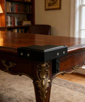 Heavy Duty Black Metal Corner Guards Set Of Four protecting a wooden table corner with a textured finish.