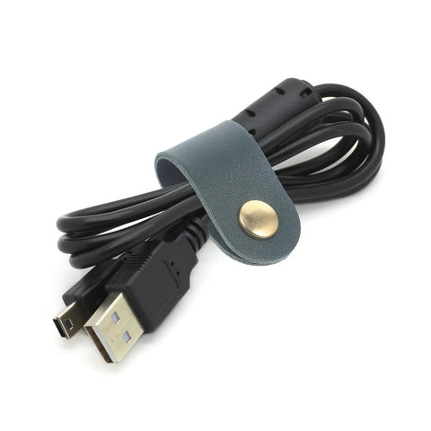 Premium Cable Organizer Straps keep your headphone wires and phone chargers hella neat on the go with dark green leather fastener.