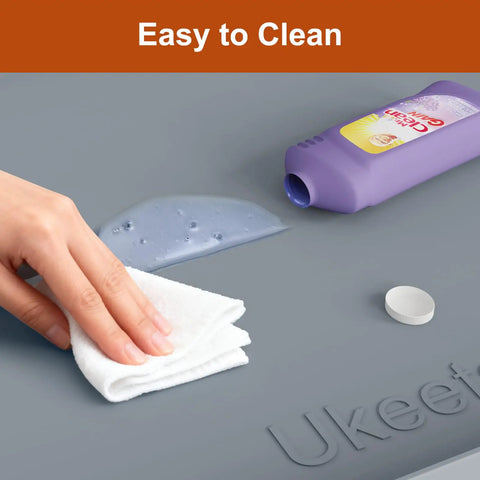 Hand wiping spill on gray Leakproof Silicone Mat With Raised Edge Extra Thick Under Sink Mat For Kitchen And Bathroom