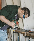 Woodworker using 70 Piece Half Inch Shank Tungsten Carbide Router Bit Set for precise cuts in wood