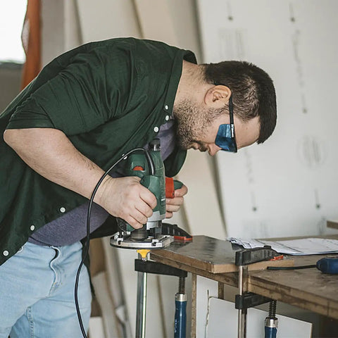 Woodworker using 70 Piece Half Inch Shank Tungsten Carbide Router Bit Set for precise cuts in wood