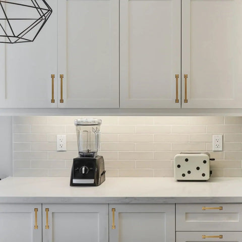 Hella Durable Five Inch Antique Brass Cabinet Pulls And Drawer Handles With Smooth Satin Finish on white cabinets above kitchen counter.