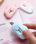 9 Pack Retractable Box Cutter Set With Mini Letter Opener And Cute Cloud Charm in pink, white, and blue on an open book