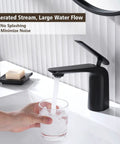 A hand holding a glass under Matte Black Bathroom Sink Faucet With Single Handle, Deck Mount 1 Hole, Brass Body pouring water.