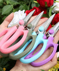 Pro Grade Floral Shears For Flowers And Garden Pruning, Heavy Duty High Carbon Steel Pruner held in hands among roses