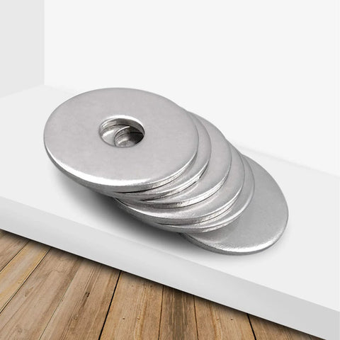 Angled side view of five stainless steel Fender flat washers, 1/4 in hole, 1 in OD