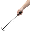 Hand holding Badass Heavy Duty Dutch Oven Lid Lifter with heat resistant grips for handling hot pots.