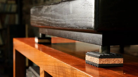 Cork Isolation Pads For Turntables, 1 Inch Thick, Pack Of 4, installed under a turntable on a wooden surface to reduce vibrations.