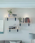 Rock Solid Heavy Duty Metal Corner Brackets For Floating Shelves in matte black holding decorative items on wall shelves.