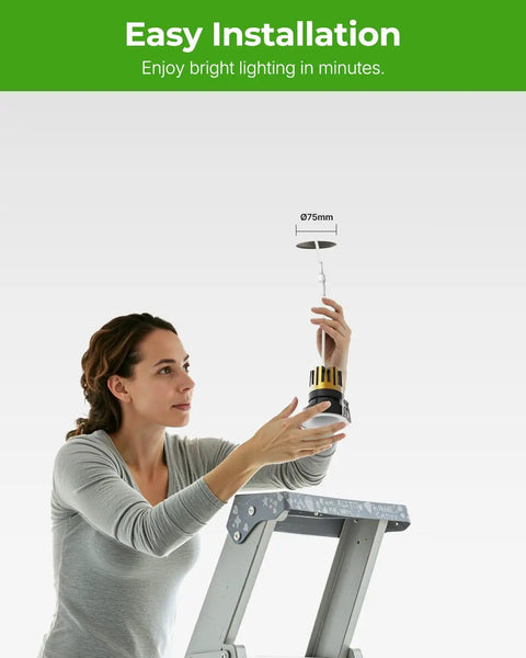 Woman installing YOVELOS 6-Pack 10W Trimless Recessed LED 3 Inch Slim Spotlight on a ladder, showcasing easy installation.
