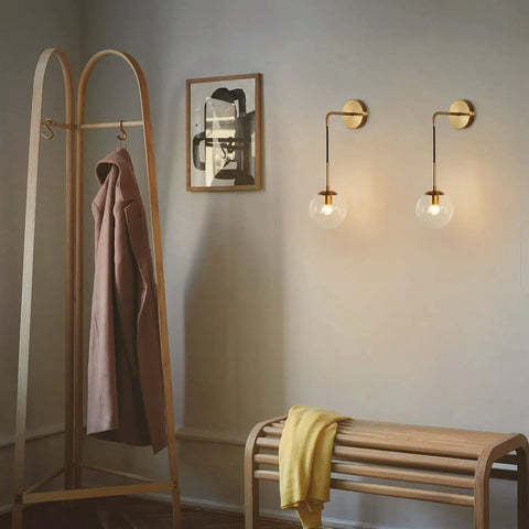 Mid Century Modern Globe Wall Sconce Set Of Two In Brushed Brass Gold With Clear Glass Ball Lamps, warm glow in living room