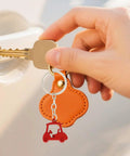 Hand holding car key with red golf cart zinc alloy keychain, part of Two Piece Golf Keychains Set In Zinc Alloy Durable Golf Cart Key Ring