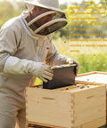 Beekeeper using 2 Pack 3.5L Beehive Feeder Set With Beeswax Coated Frames for honeybee hives, cedar wood structure visible