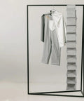 Hella Handy 10 Layer Hanging Shoe Rack Saves Gobs Of Space Perfect For Boots Sneakers Hats And Bags With An Easy Fold Up Design hanging next to a gray outfit.