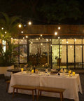 Outdoor dining area with 120 Ft Outdoor LED String Lights Waterproof With 40 Shatterproof Warm Edison Bulbs creating cozy vibes.