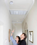 Couple looking up at a Hardwire Smoke Detector With Nine Volt Battery Backup And No Drama Front Load Door For Straight Swap Install.