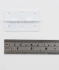 Heavy Duty White Iron Folding Butt Hinges 2.5 Inch with zero play action and measuring tape for size reference.