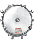 Round metallic low‑pressure gas regulator cover with bolt lugs around edge and bottom inlet fittings; top orientation mark.