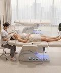Professional Fully Electric Facial Massage Table With Lift For Estheticians, patient receiving treatment on white padded spa bed.