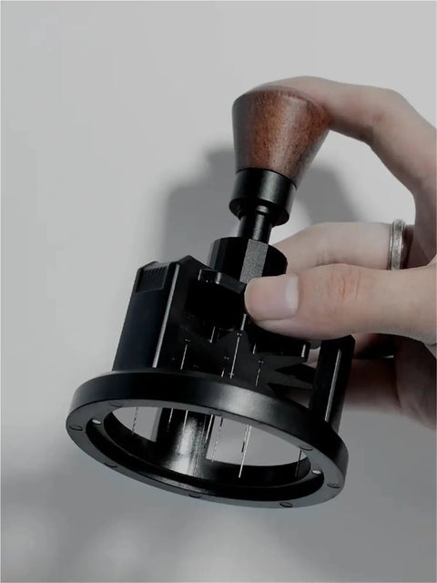 Hit The Mark Every Time With This Rock Solid 58mm Magnetic Stirrer For Espresso Portafilter Featuring Rotary Needle Distributor To Flatten Coffee Beds Smoothly And Elevate Your Home Brewing Game, held in hand, showing wooden handle.