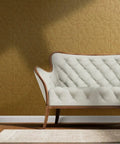 Rustic Floral Pink Gold Metallic Wallpaper With Fibrous Texture Pvc Free Wall Covering behind a white tufted loveseat.