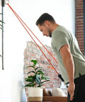 Man exercising with Top Tier Space Saving Home Gym Resistance Band System With Gliding Wall Track Three Foot Aluminum Mount.