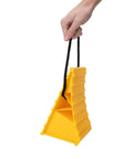 Side view: Camco yellow plastic wheel chock with rope handle for trailers; supports tires up to 26-in