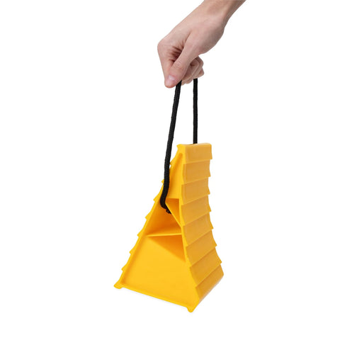 Side view: Camco yellow plastic wheel chock with rope handle for trailers; supports tires up to 26-in