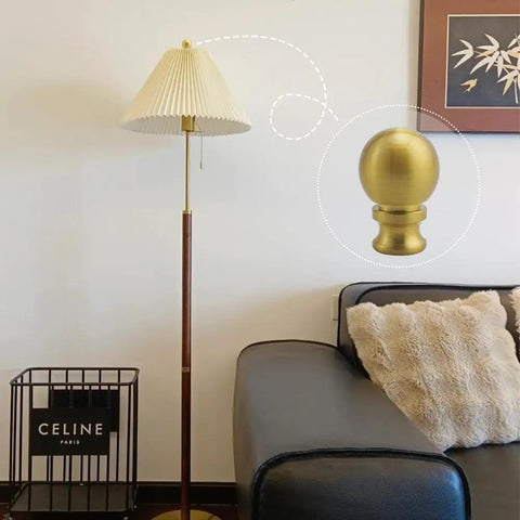 Two Piece Antique Brass Lamp Finials Set For Lamp Shade Nut Screw Cap Metal Knob Topper Decorative Replacement DIY Table Or Floor Light Harp Adapter Kit shown installed on a floor lamp next to a sofa.