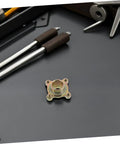 Beefed Up Heavy Duty Go Kart Rear Axle Sprocket Mount With 28 Teeth Metal Hub for ATV and Quad Bike next to tools on a table.