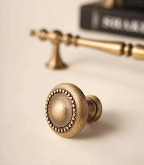 Close-up of round antique brass knob from Vintage Cabinet Pulls 2 Pack Antique Brass Crown Shape Handles For Cabinets Dressers Wardrobes And Drawers