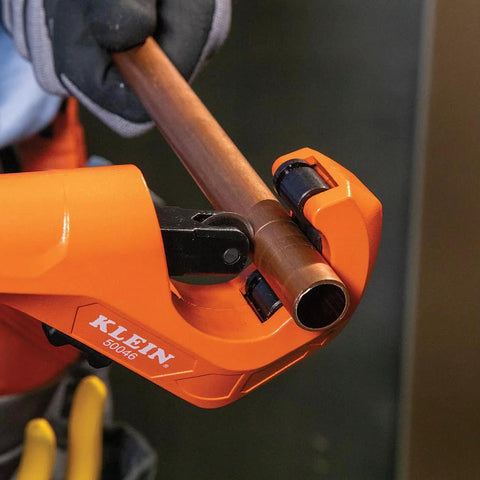 Klein Tools 50046 tubing cutter, orange, gripping a copper tube