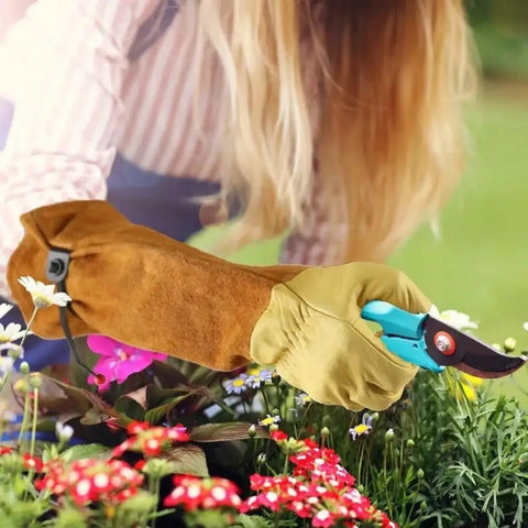 Person using Rugged Leather Work Gloves For Men And Women Built Tough Cowhide Gardening Gloves Puncture And Cut Resistant with Elbow-Length Gauntlet for gardening.